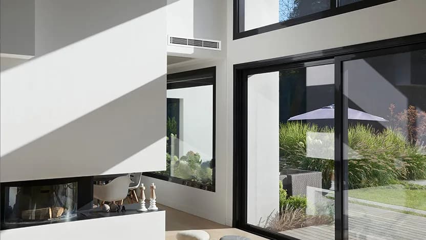 Séjour contemporain climatisé par un gainable Mitsubishi Electric : seule une bouche de diffusion discrète est visible en haut du mur