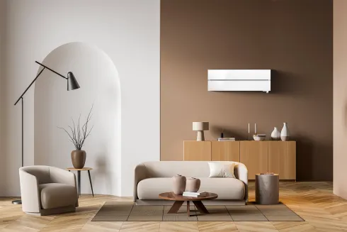 Climatiseur mural Mitsubishi Electric blanc installé dans un salon lumineux par Kozéo