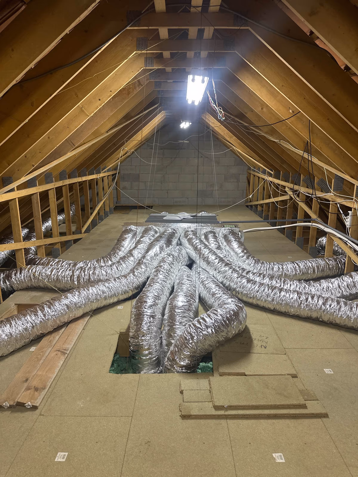 Réseau de gaines isolées d'une climatisation gainable installée par Kozéo dans les combles d'une maison à Saint-Pierre-de-Varennes, près du Creusot
