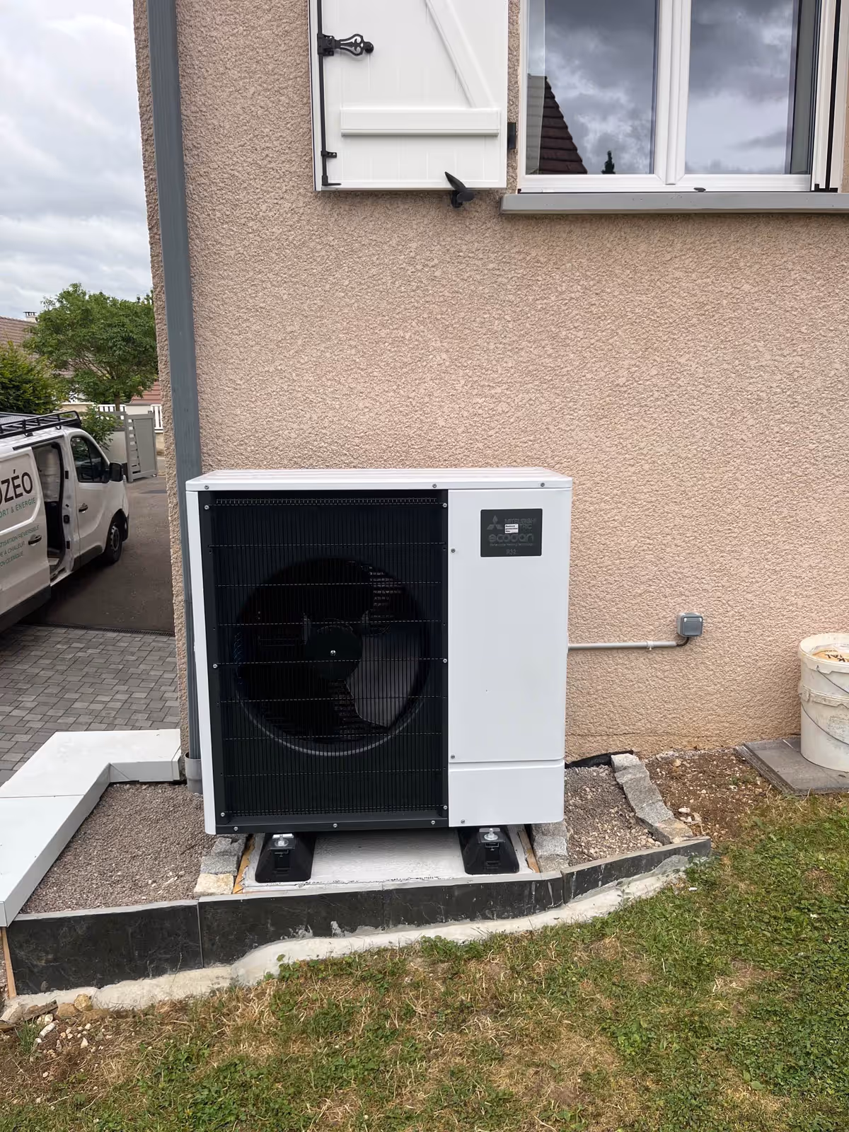 Unité extérieure d'une pompe à chaleur air-eau installée par Kozéo contre la façade d'une maison à Nuits-Saint-Georges